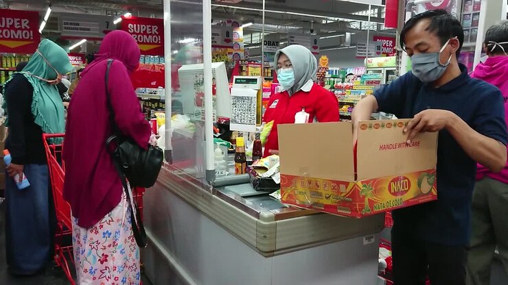 People with face mask buying groceries in the supermarket cashier during virus pandemic.