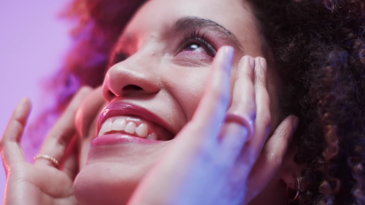 Donna meticcia con capelli scuri in luce blu e rosa, slow motion