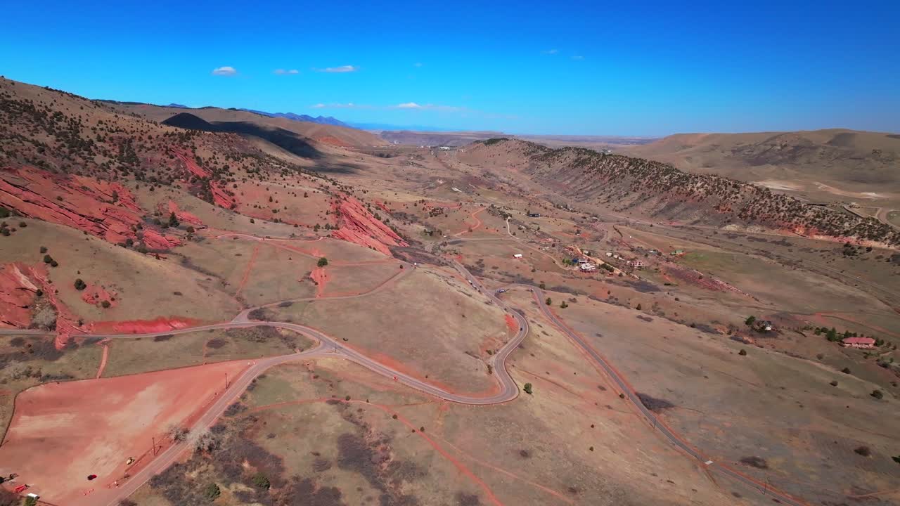 Morrison Golden i70 Colorado Red Rocks Park and Amphitheater bike hike trails aerial drone view cars front range foothills neighborhood dry mid winter sunny blue sky clouds forward pan up motion