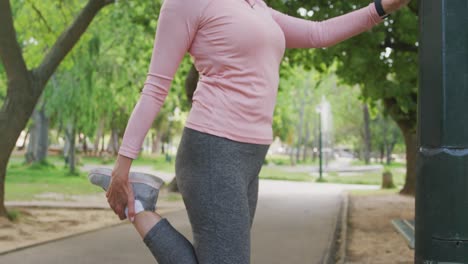 Senior-woman-stretching-her-legs-in-the-park