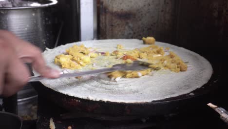 un fabricante de comida callejera prepara la comida del sur de la india dhosa