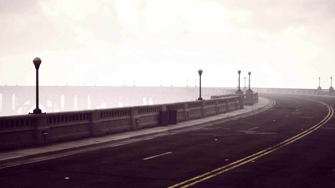 Foggy road alongside bridge with lamp posts in a serene urban landscape