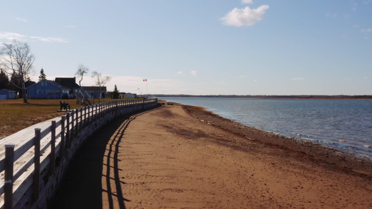 해안가 해안, 작은 마을, 캐나다 동부에 있는 아카디아 국기를 향해 천천히 이동하는 공중 드론