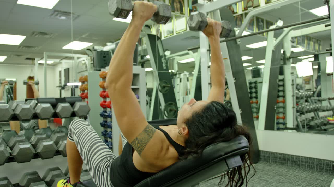 Female with muscular body exercise in training gym