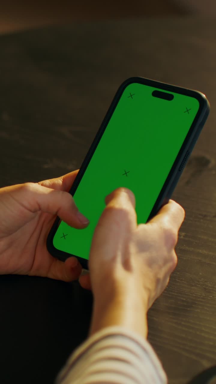 persona que utiliza un teléfono inteligente con pantalla verde