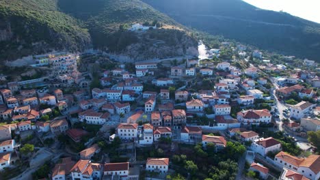 amanecer sobre el pueblo de dharmi: techos rojos, paredes de piedra y callejones estrechos en el destino turístico de la ladera de la montaña mediterránea en albania