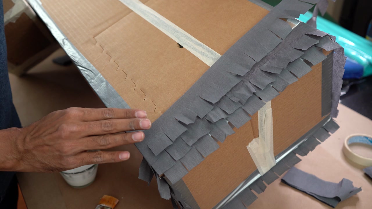 Taping gray arts paper on cardboard box, paper crafts
