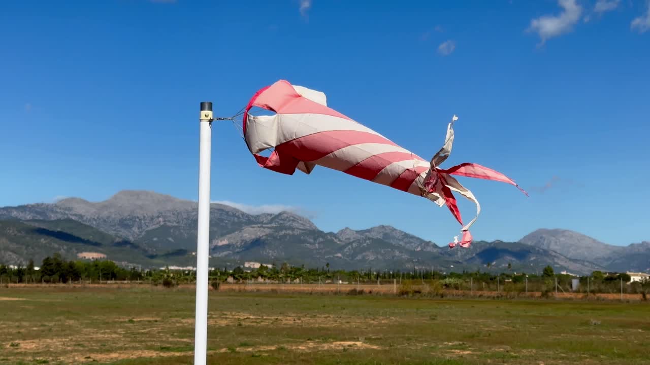 아름다운 화창한 날에 강한 날개에서 회전하는 흰색과 주황색 바람막이