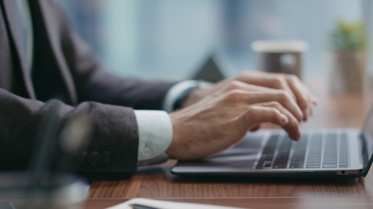 바쁜 직원이 노트북으로 타이핑하는 동안 전화를 하고 있습니다. 매니저가 전화하고 있습니다.