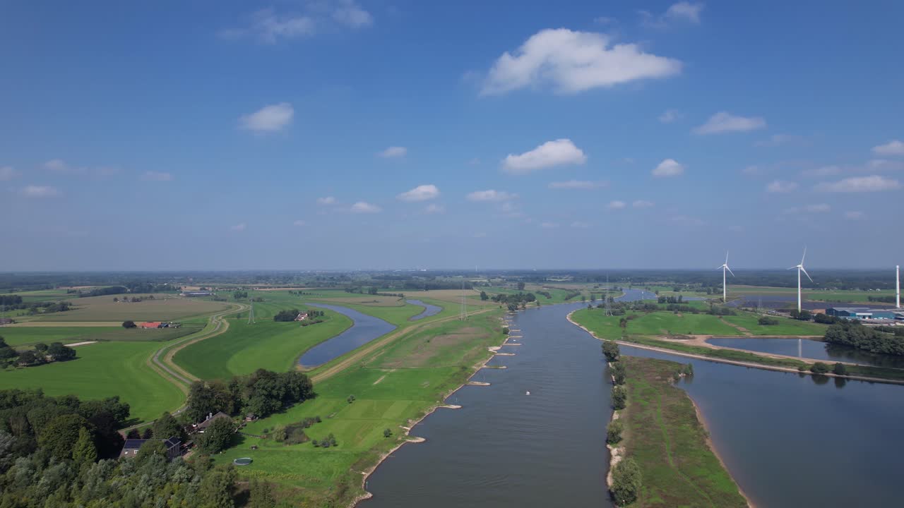 빈 화물선을 드러내는 백그라운드에서 범람원과 풍력 터빈이 있는 zutphen 근처의 ijssel 강을 따라 뒤로 공중 이동