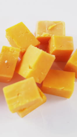 cubos de queso amarillo sobre fondo blanco