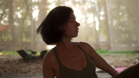 Portrait-Of-A-Girl-Doing-Yoga-In-Wooden-Hut-Filled-With-Light,-The-Girl-Performs-Yoga-Stands-And-Elements