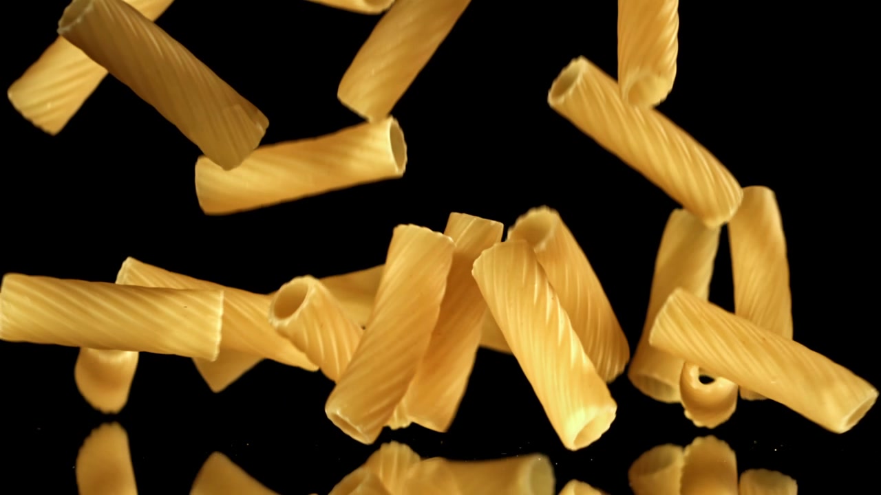 Movimento rallentato di pasta secca che cade su sfondo nero