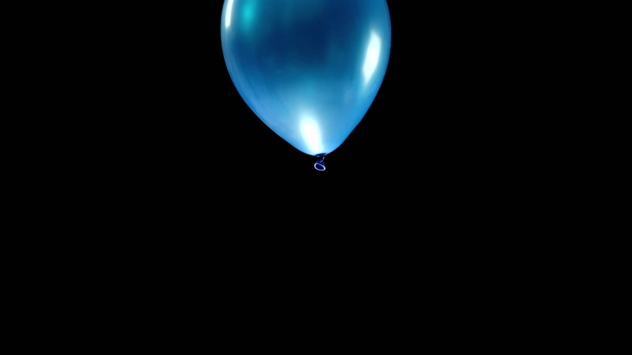 Watch a single blue balloon as it drifts gently through the air, showcasing a playful and vibrant moment. The simplicity of the balloon in motion against the open sky creates a joyful scene.