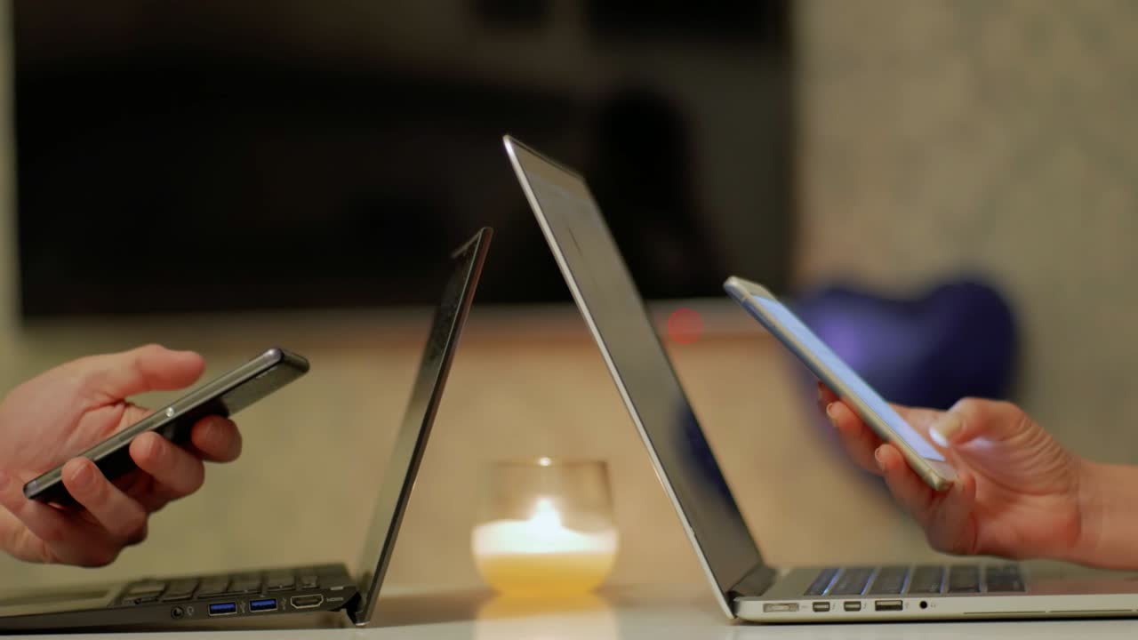 Couple Student's Hands Working on Smart Phone near Laptops CLOSE UP