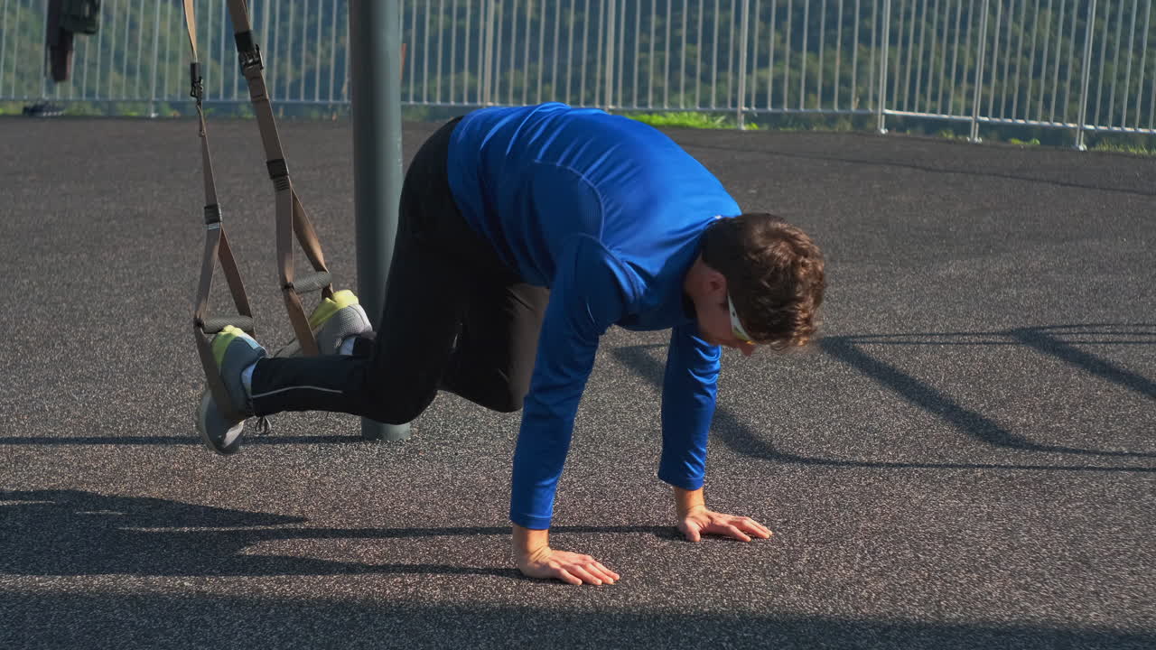 hombre realizando un ejercicio de entrenamiento de suspensión al aire libre