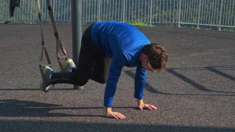 man performing suspension training exercise outdoors