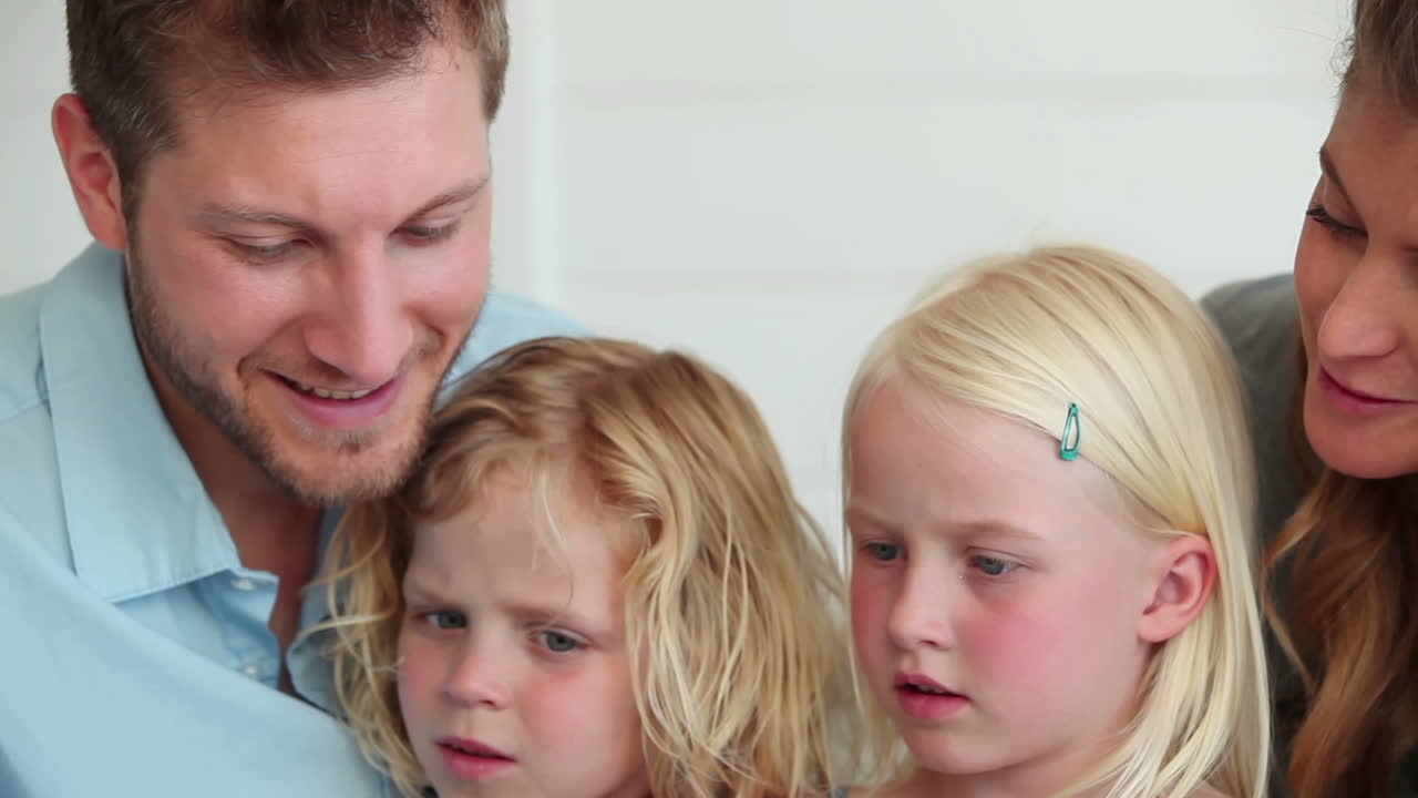 가족들이 함께 태블릿 컴퓨터에서 무언가를 보고 있습니다.