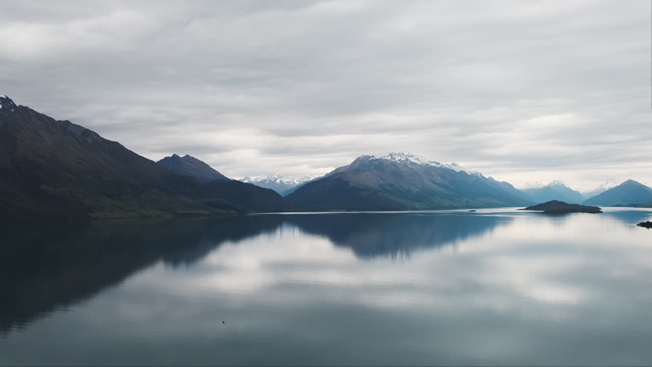cacerola lenta, reflexiones pacíficas de la montaña en el lago vidrioso, día nublado