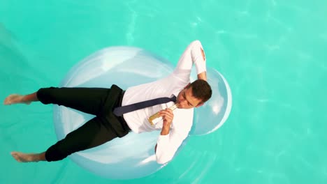 businessman drinking beer on inflatable