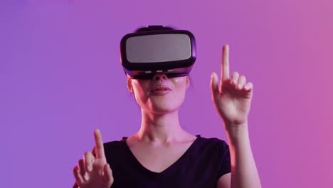 mujer asiática feliz usando auriculares vr y tocando la pantalla virtual en fondo púrpura, cámara lenta
