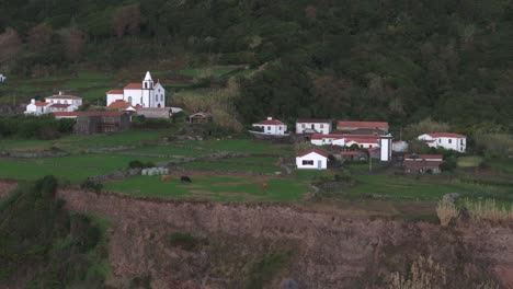 fotografía lateral de una iglesia blanca en una pequeña ciudad en la isla de flores, azores