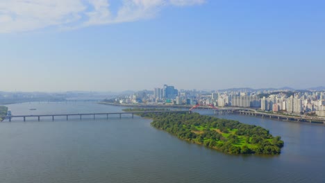 Un-Dron-Disparó-Hacia-Atrás-Sobre-El-Río-Han-Desde-La-Isla-Bamseom-Antes-De-Pasar-Por-Encima-Del-Puente-Mapo-En-La-Ciudad-De-Seúl-Durante-El-Día