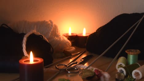 fondo acogedor de una mesa de tejer con velas y equipo de tejer