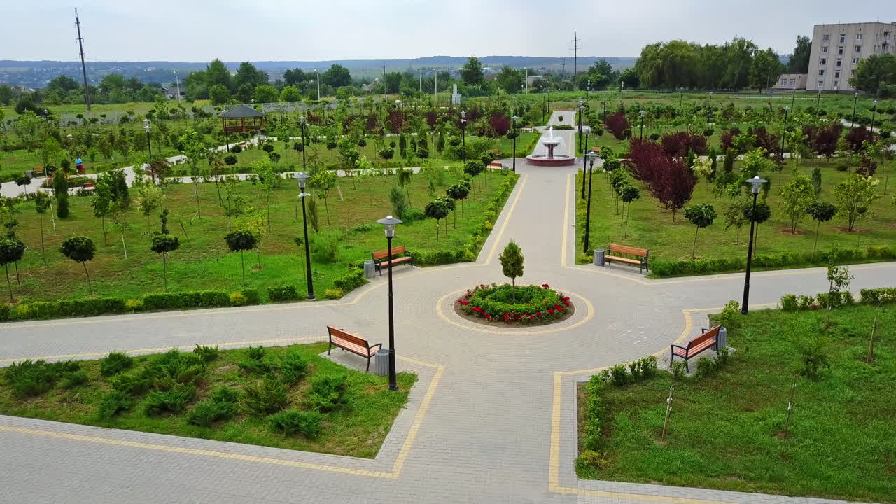 Paved paths in the newly created park with young trees. Garden for rest and walk in the city. Top view.