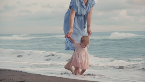 caucasian baby walking by ocean coast