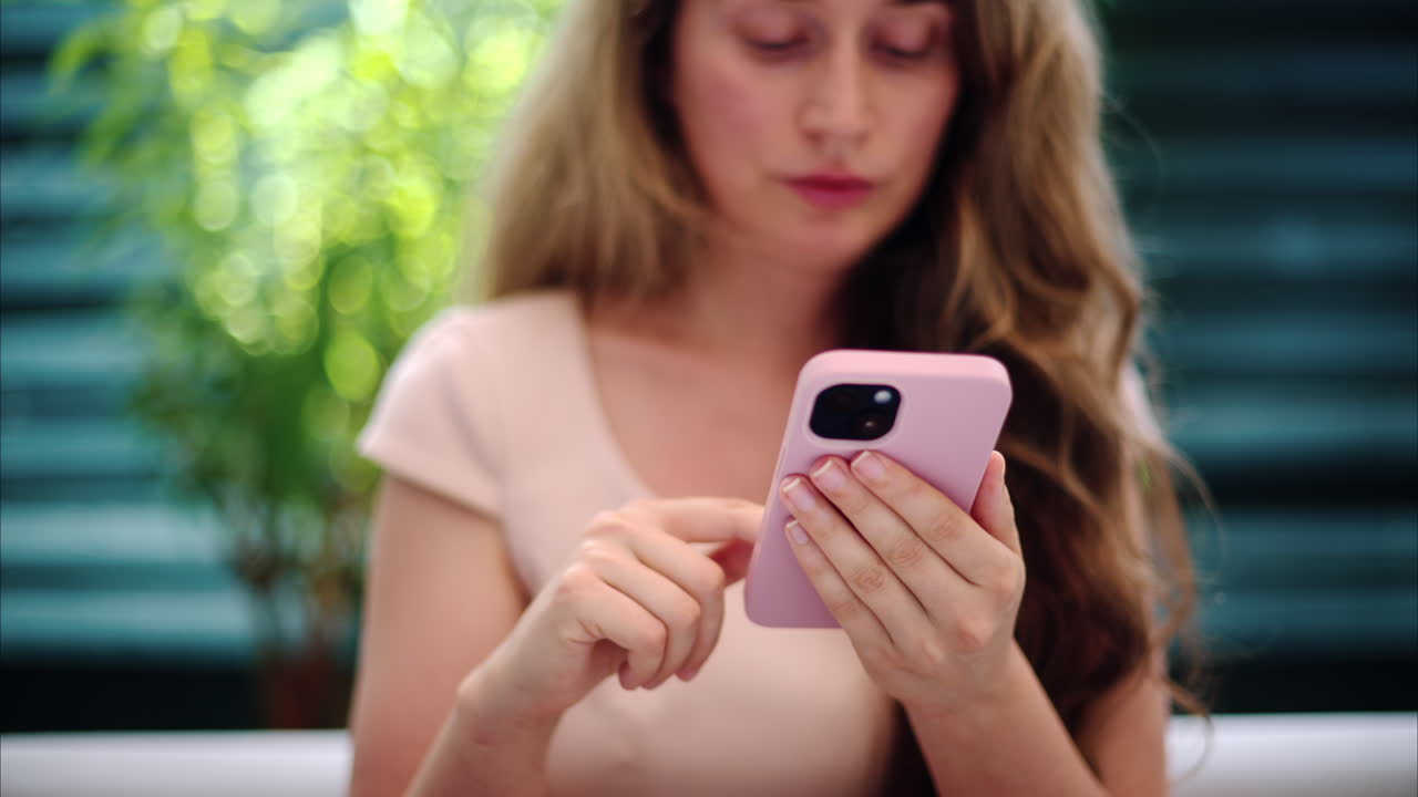 Brunette woman scrolling on the phone outside in daylight