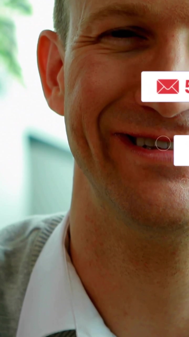 La telecamera si alza, un uomo sorride mentre icone social fluttuano sul suo viso, i conteggi aumentano, lasciando spazio per il coinvolgimento.