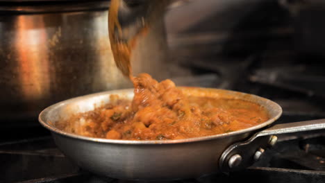 chef stirs authentic chana masala in commercial restaurant kitchen, slow motion slider close up hd