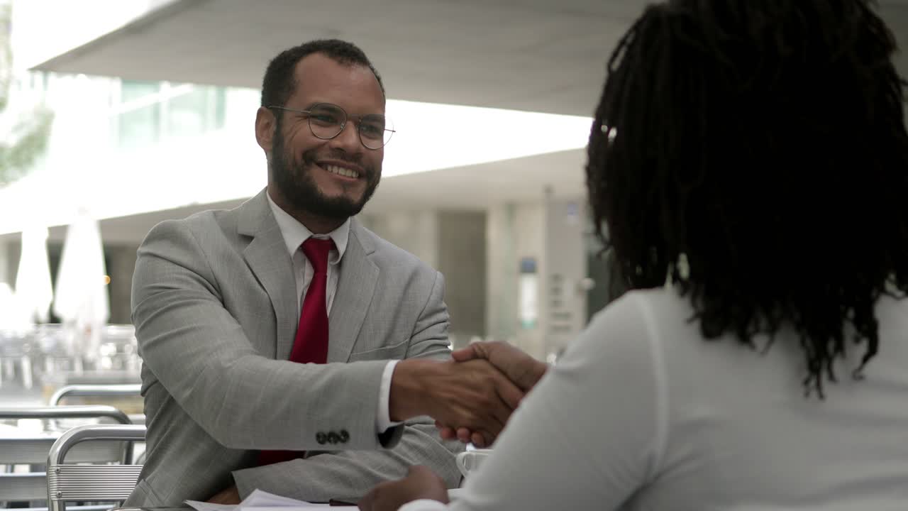 Focused bearded man listening colleague and shaking hands