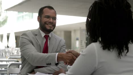 Focused-bearded-man-listening-colleague-and-shaking-hands