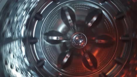 stainless steel washing machine drum turning spin cycle, futuristic industrial look of modern machinery