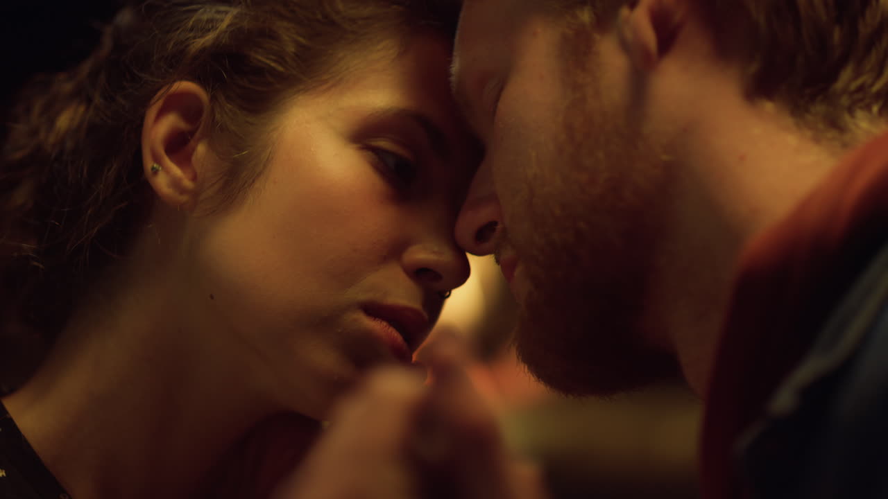 Closeup lovers enjoy sensual date. Romantic couple faces touch nose at evening.