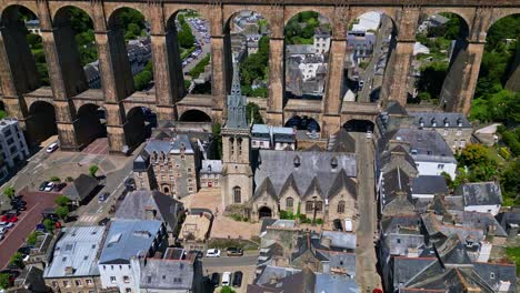 lateral drone shot of saint-melaine church and morlaix viaduct in brittany, showing the historic town and stone structures