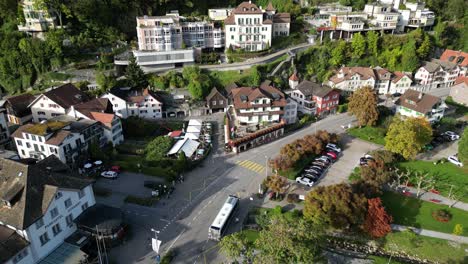 static aerial shot of a city in the hilly region of europe with large mansions and green trees around the place