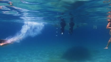 Beautiful-underwater-footage-of-red-hair-little-child-girl-diving-from-motorboat-in-crystal-clear-deep-blue-sea-water-with-diver-mask