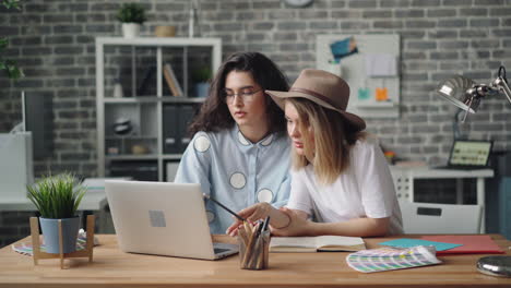 two women collaborating on a design project in an office