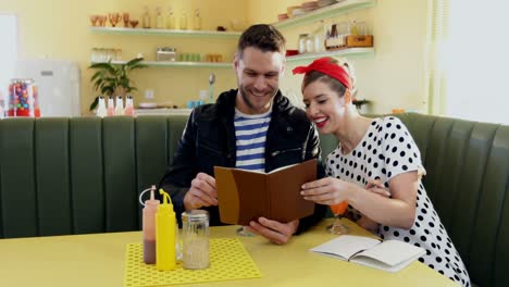 Couple-looking-at-menu-card-4k