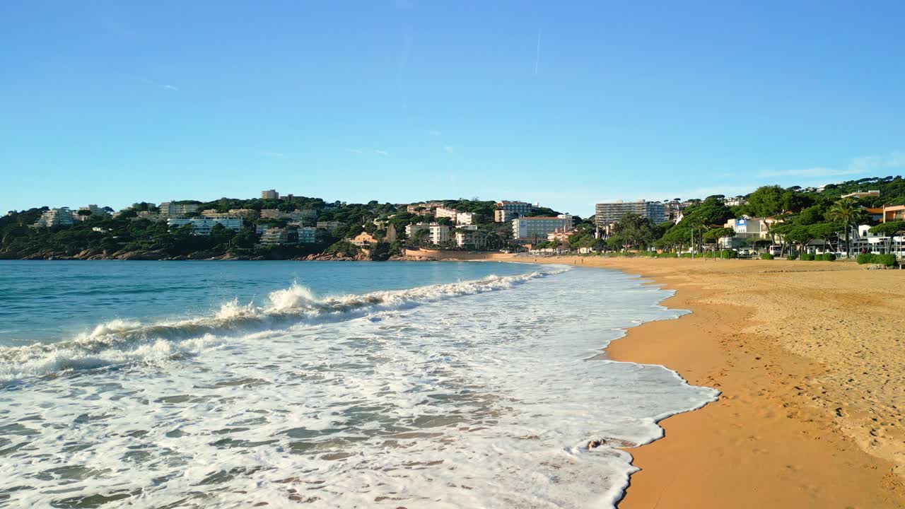 Gentle waves rolling in on platja de sant pol beach in s'agaró, spain