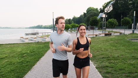 happy couple running together in the city near a river 1