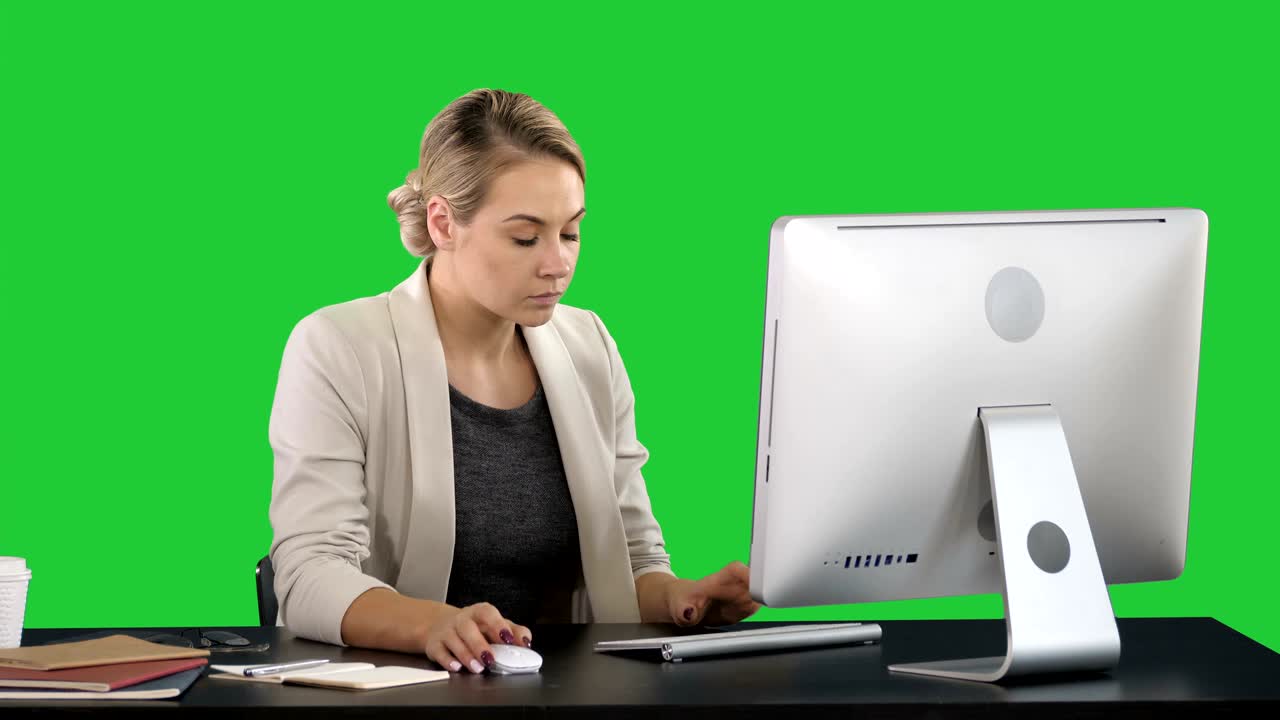 Classy happy businesswoman working at computer on a Green Screen, Chroma Key