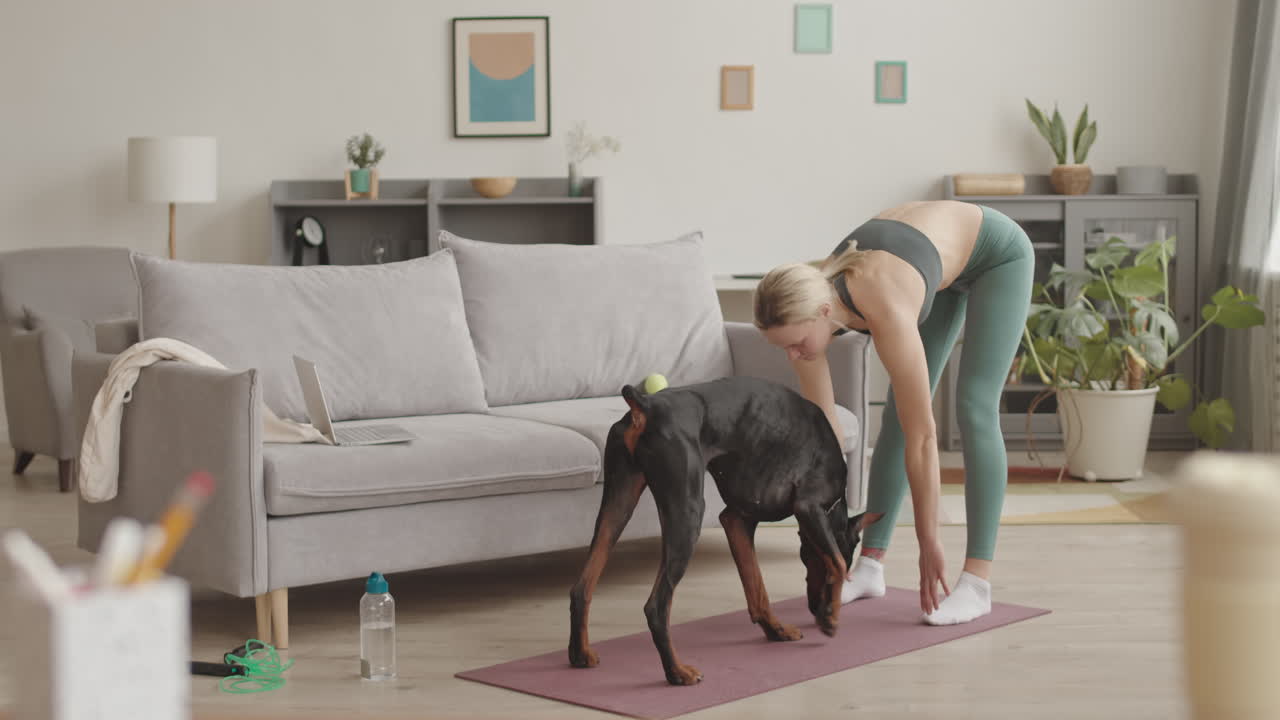 Caucasian Dog Owner Stretching at Home