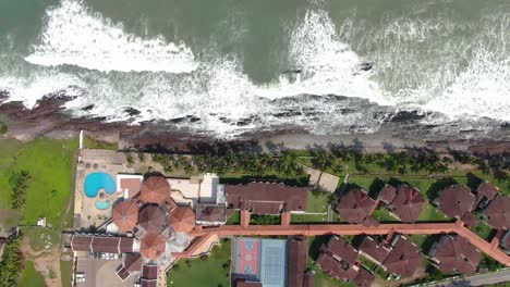 sea waves by house aerial view tracking