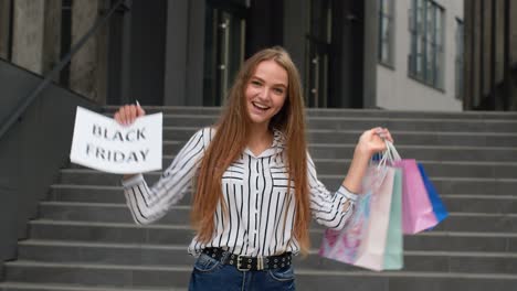 cheerful girl showing black friday inscription text advertisement. online shopping with low prices