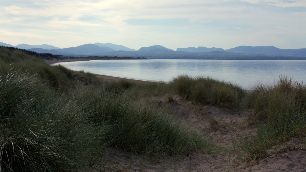 Wide shot in the dunes looking east over the beach at Llanddwyn beach and at the Newborough National Nature Reserve