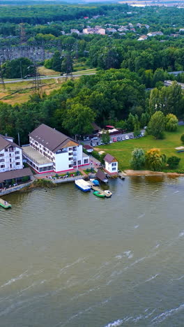 beautiful landscape of the city on the river bank. urban area with exuberant greenery from aerial perspective. vertical video